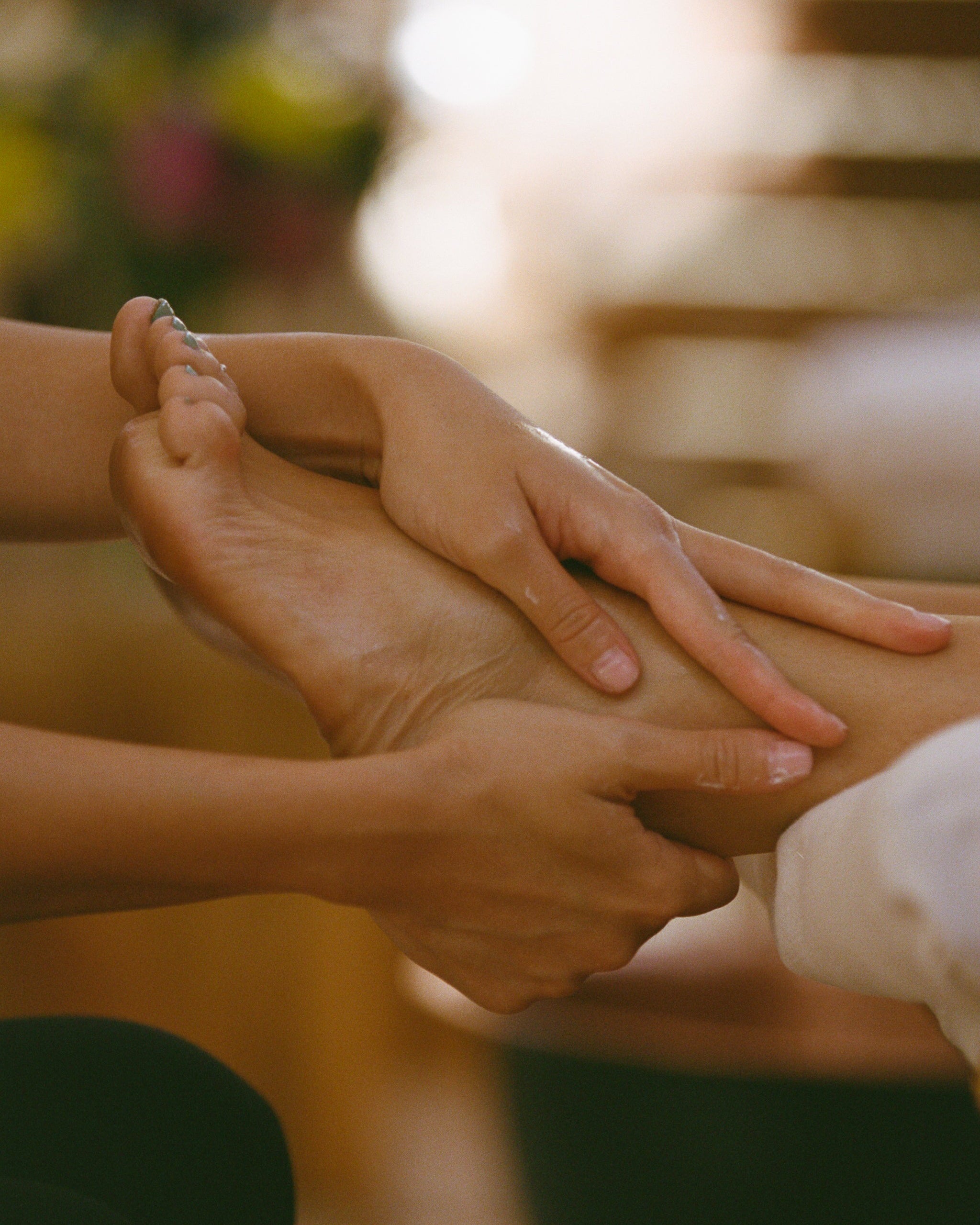 Close-up of two hands being massaged with a blurred background
